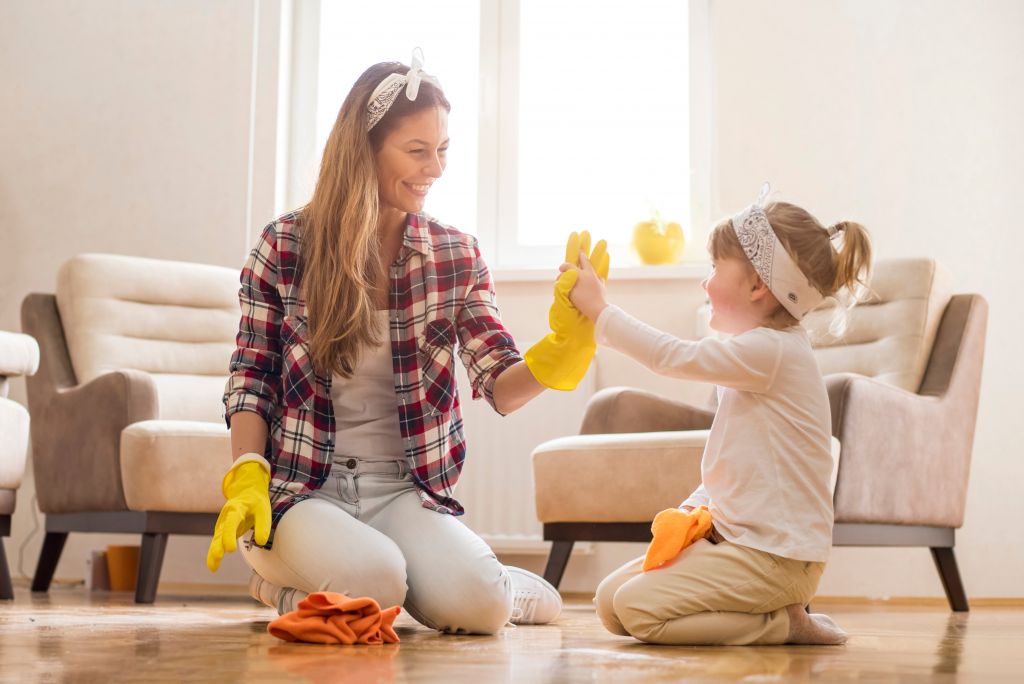 daughter and mother cleaning home together and cleaning up and having fun
