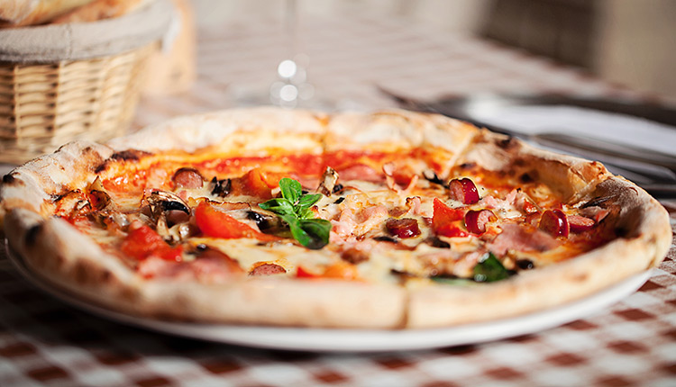 pizza-sitting-on-the-table a pizza sitting on the table with a bread basket and wine