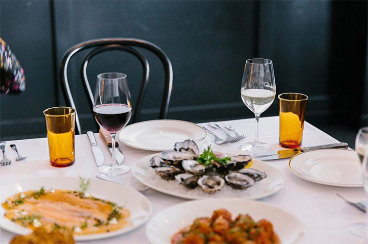 bouvier-bar a restaurant table filled with food and drinks
