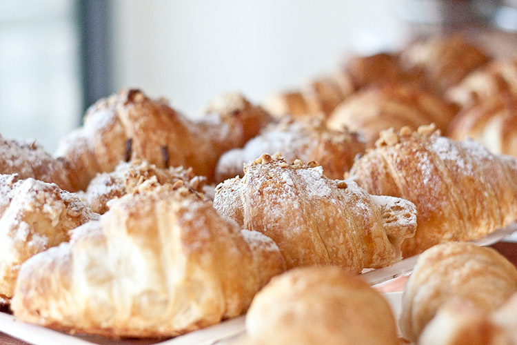 a group of croissants with powdered sugar and almonds on top