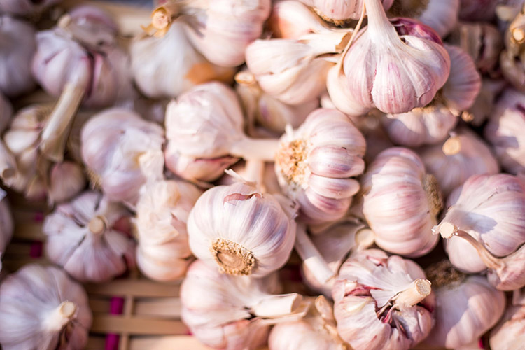 garlic cloves clumped together in a woven basket