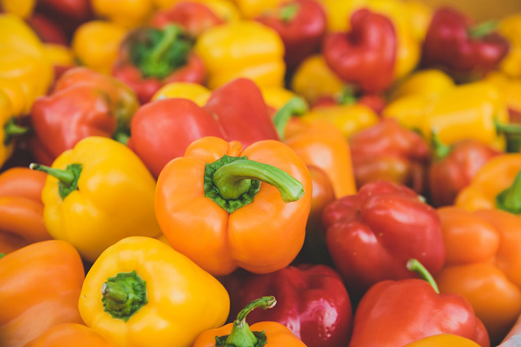 red, yellow and red capsicums sitting in a bunch together