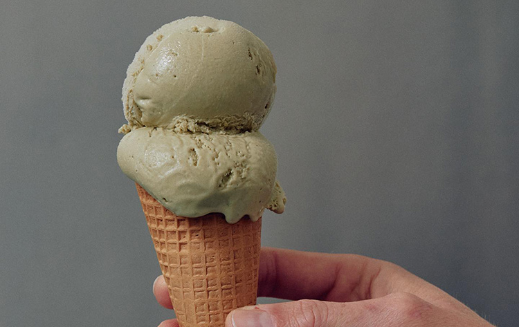 billy-van-creamery a person holding an ice cream cone with pistachio ice cream inside