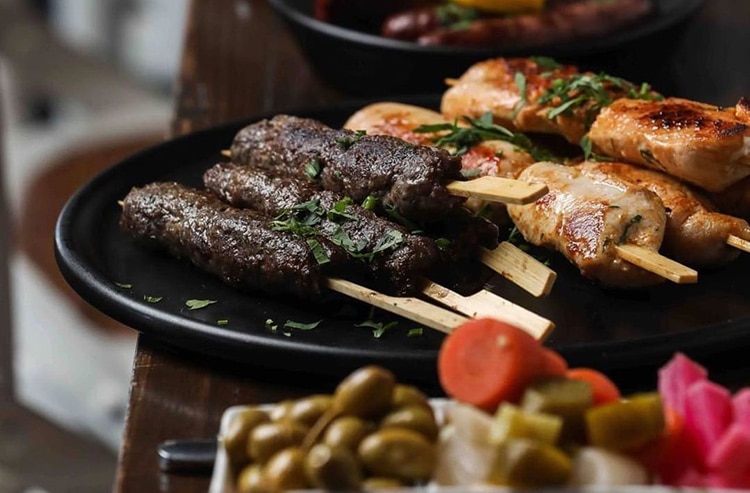 mama-manoushe meat skewers sitting on a table at a restaurant