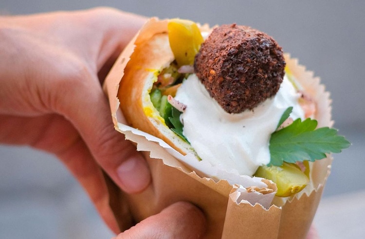 very-good-falafel a person holding a falafel pocket